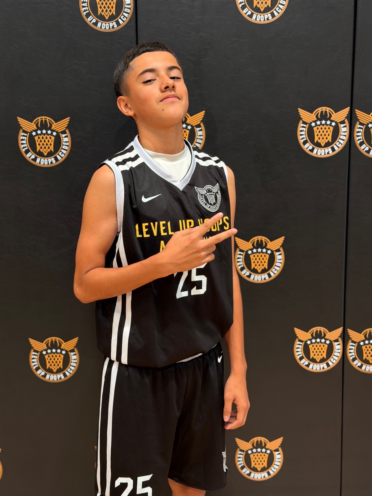 Level Up Hoops athlete #25 in front of academy backdrop