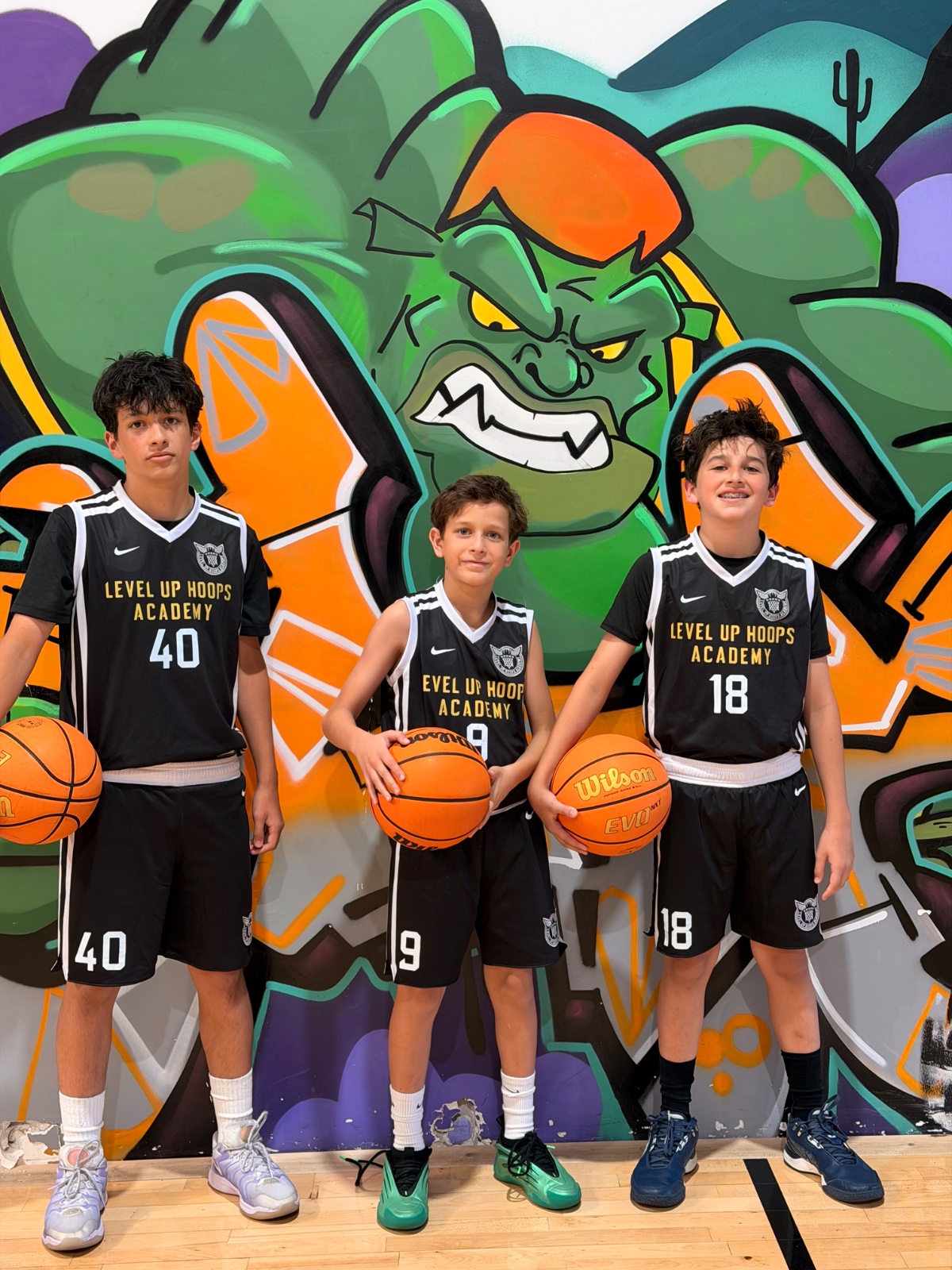 Level Up Hoops athletes #40, #9, #18 holding basketballs