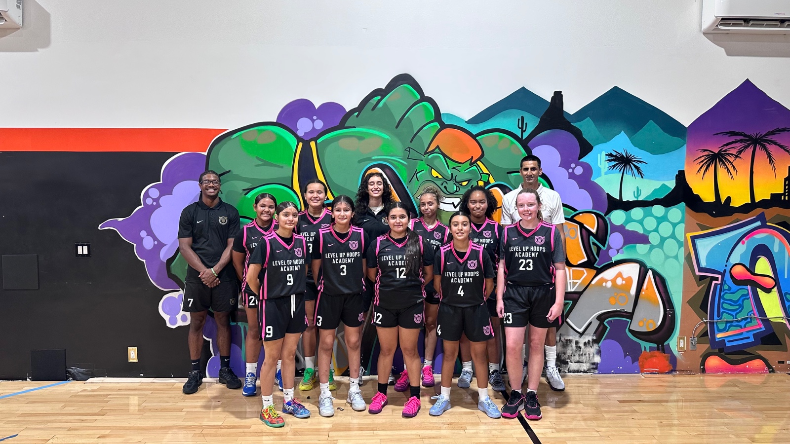 Girls' team full roster — wide mural backdrop