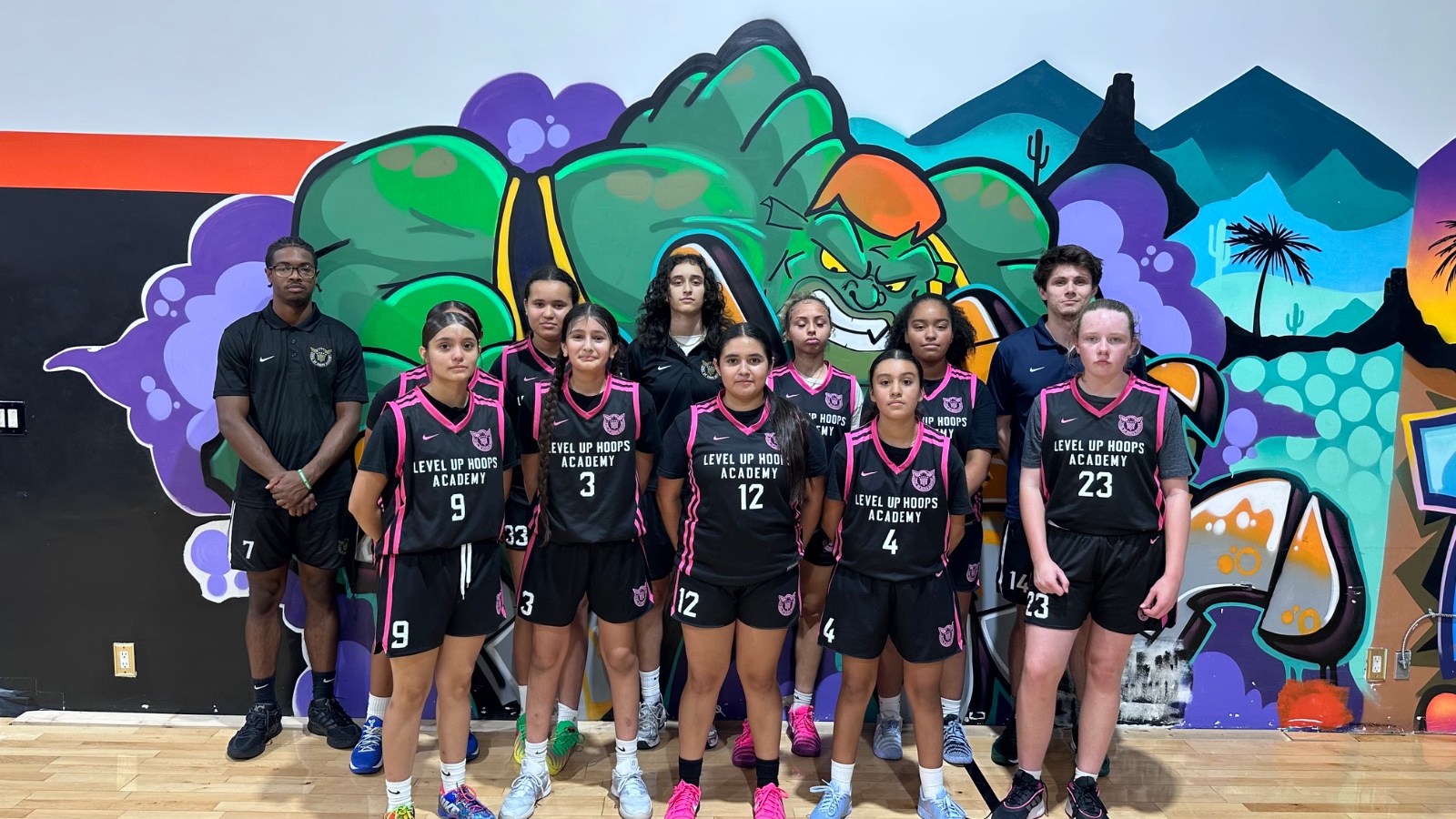 Girls' team posed with coaches at the academy gym
